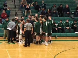 Boys Basketball players  about leave the huddle after a timeout.