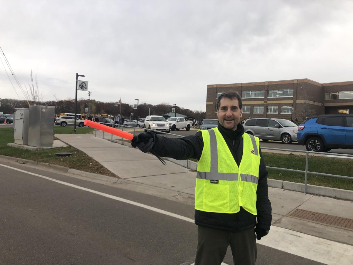 Paul+Cicmil+directs+traffic+near+the+entrance+to+the+north+parking+lot%2C+chatting+with+students+as+they+cross+the+nearby+crosswalk.