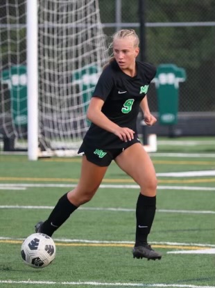 Ivy Nystrom kicks soccer ball