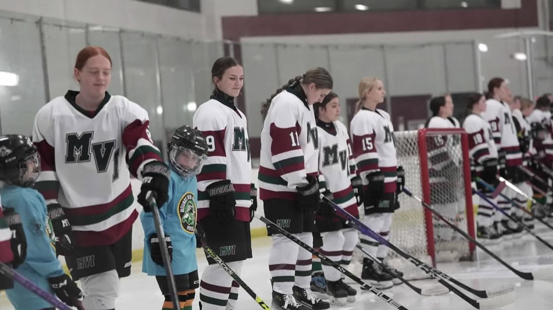 The players and Mounds View-Irondale youth players stand for the national anthem.