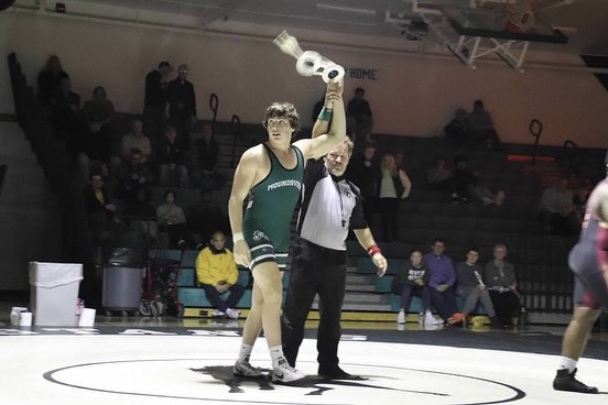 Quin Morgan holds trophy at wrestling tournament