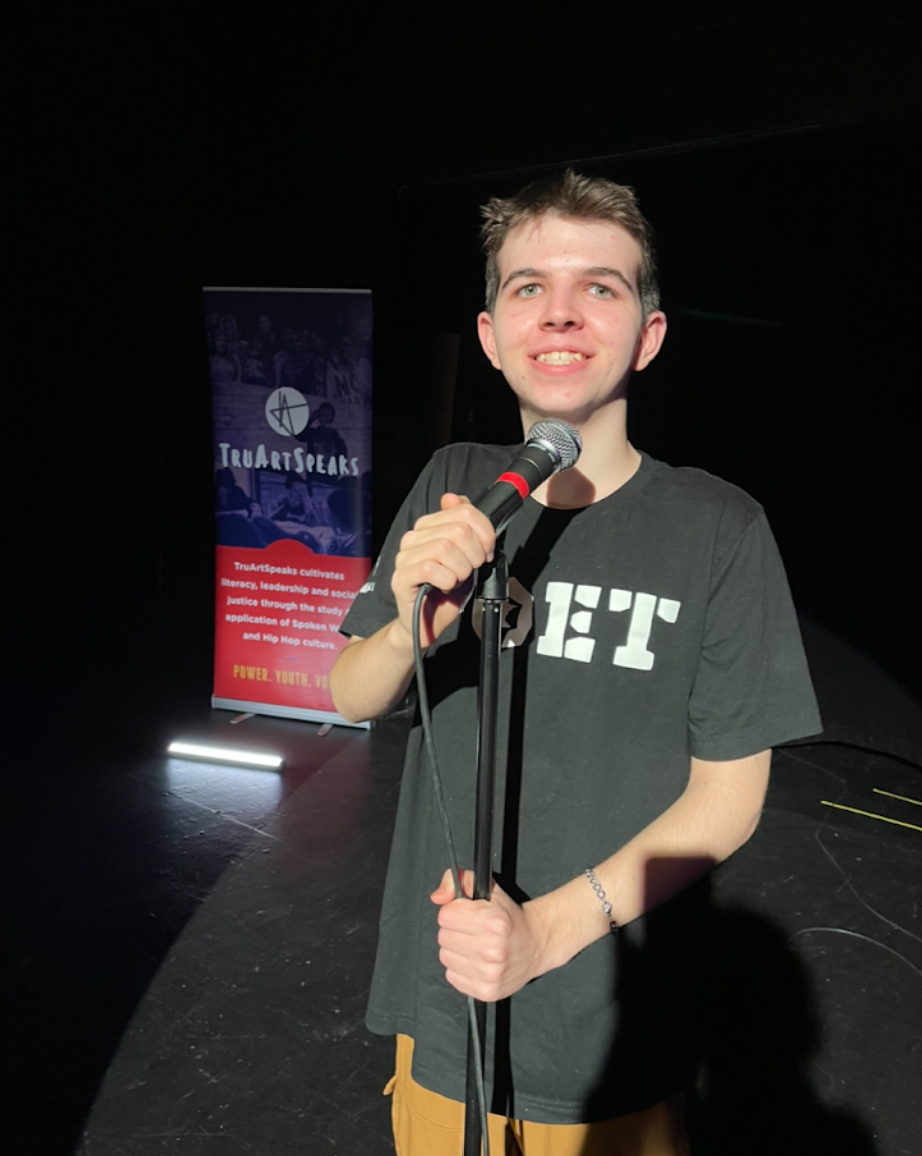 Canas on stage at the Teen Poetry Slam Contest while his poem was read by Azure Merrill.